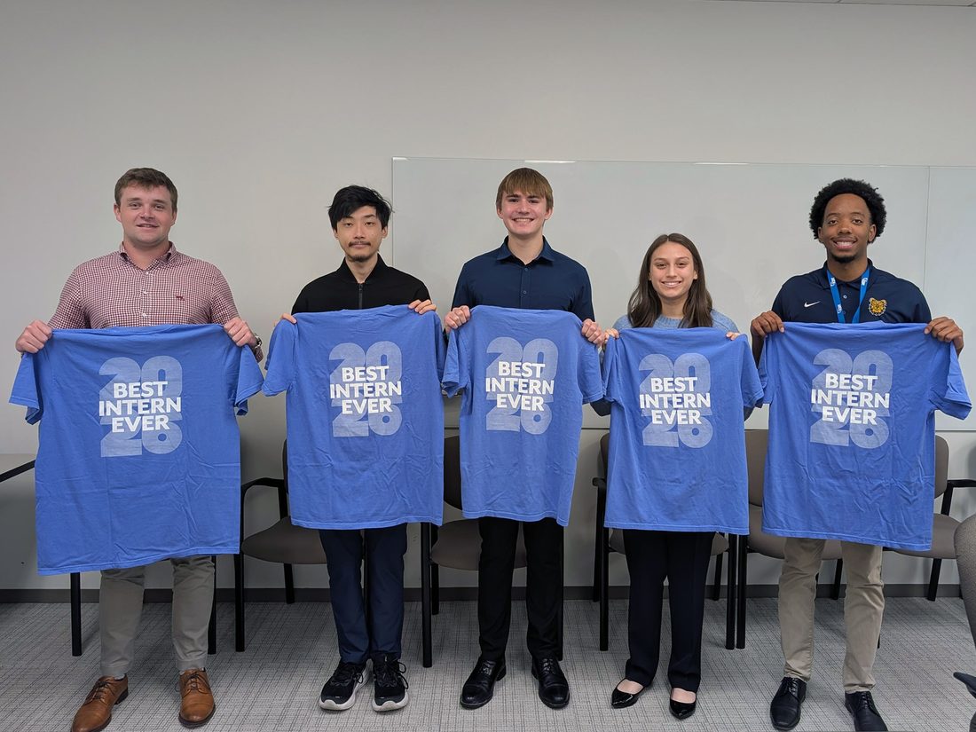 Five KBR interns holding "Best Intern Ever 2026" t-shirts at Intern Day 2026
